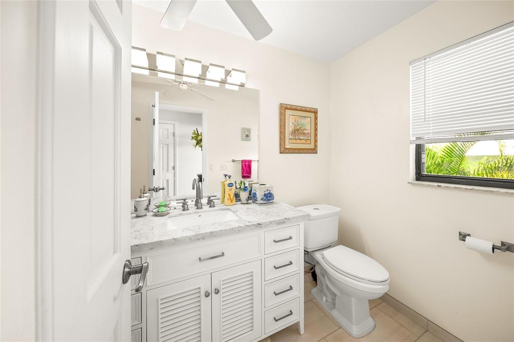 3421 Bayou Sound Longboat Key, FL 34228 - Photo 35 of 79 a bathroom with a toilet a sink a mirror and a window