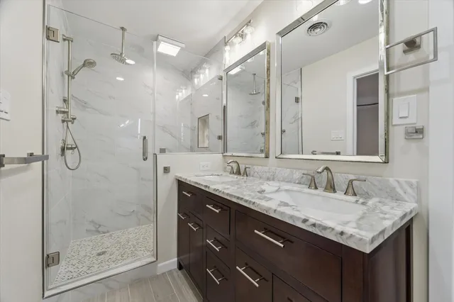 a bathroom with a granite countertop sink shower and a mirror