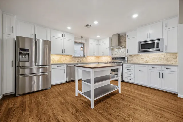 a kitchen with stainless steel appliances a stove sink and microwave