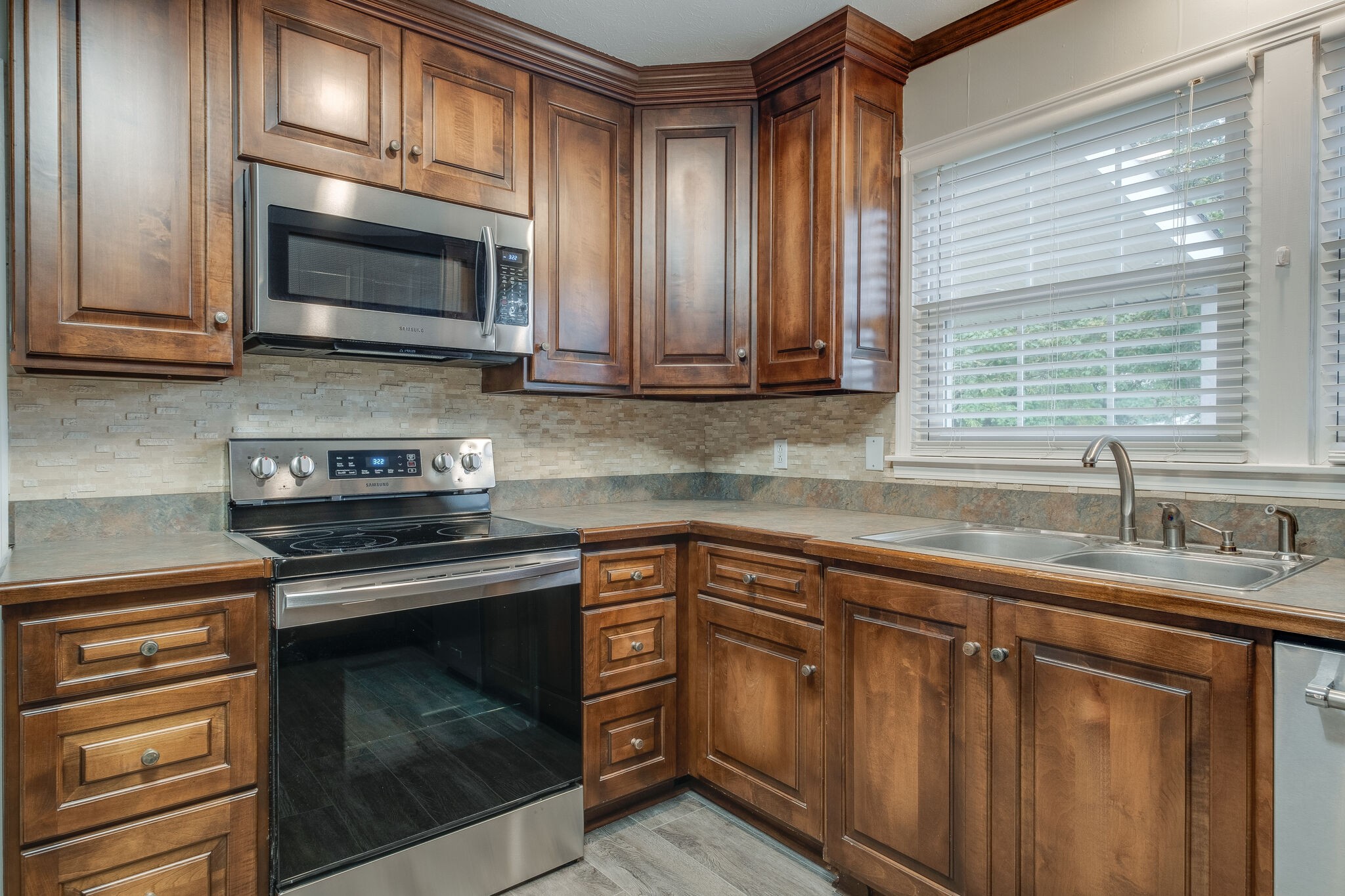 8860 Lyles Road Lyles, TN 37098 - Photo 12 of 36 a kitchen with granite countertop a stove microwave and sink