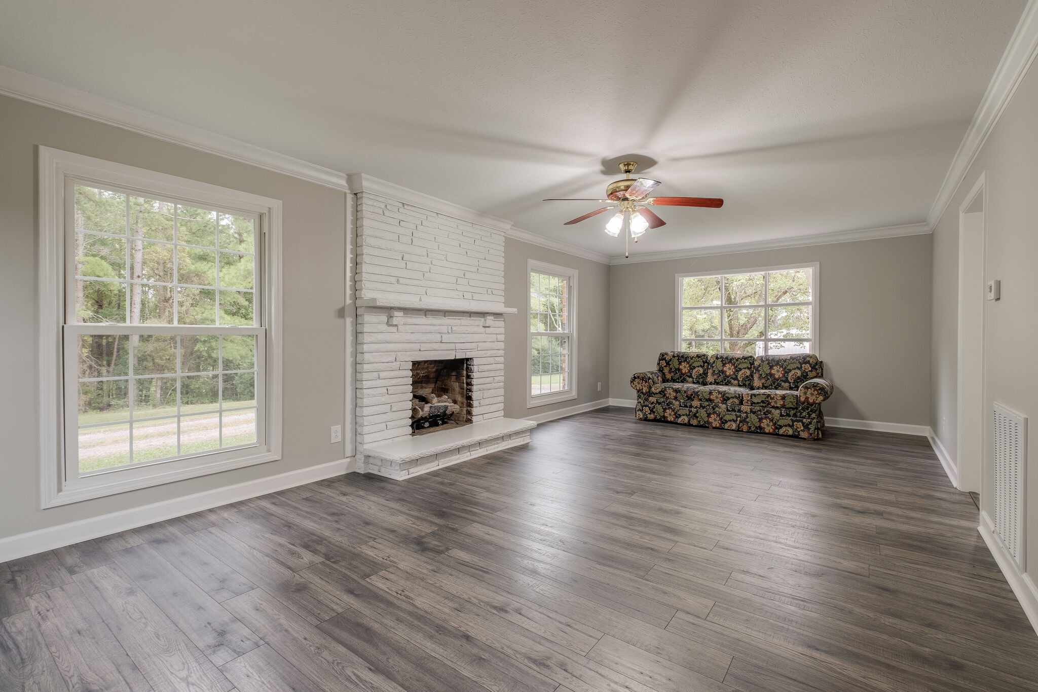 8860 Lyles Road Lyles, TN 37098 - Photo 9 of 36 a view of a livingroom with a fireplace a ceiling fan and windows