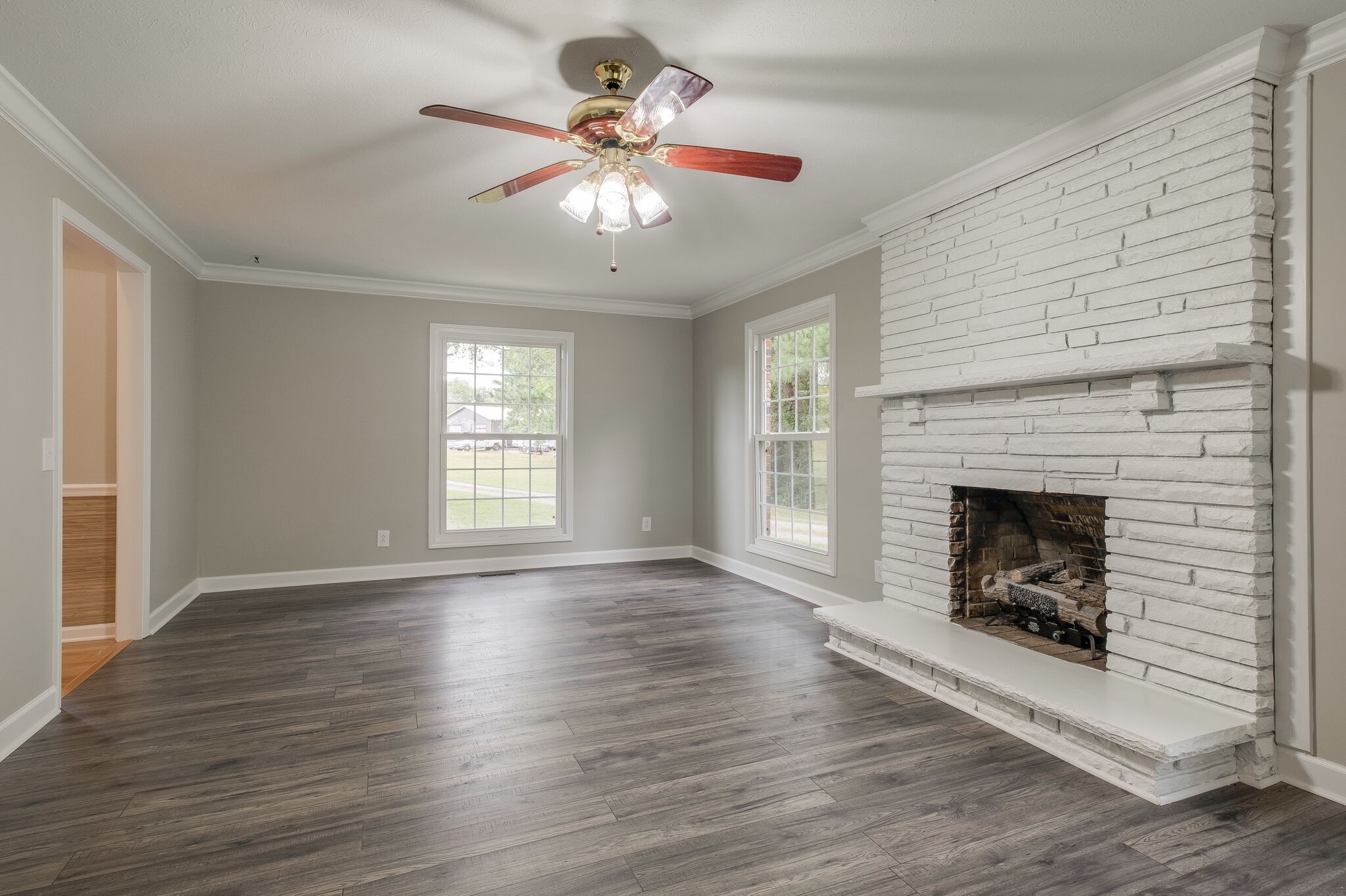 8860 Lyles Road Lyles, TN 37098 - Photo 10 of 36 a view of an empty room with wooden floor fireplace and a window