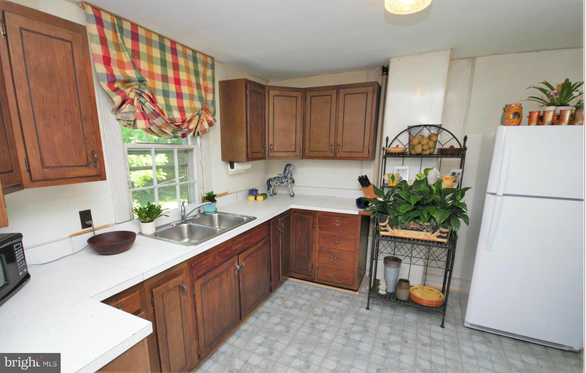 6109 Falls Road Baltimore, MD 21209 - Photo 13 of 26 a kitchen with a sink a refrigerator and a stove