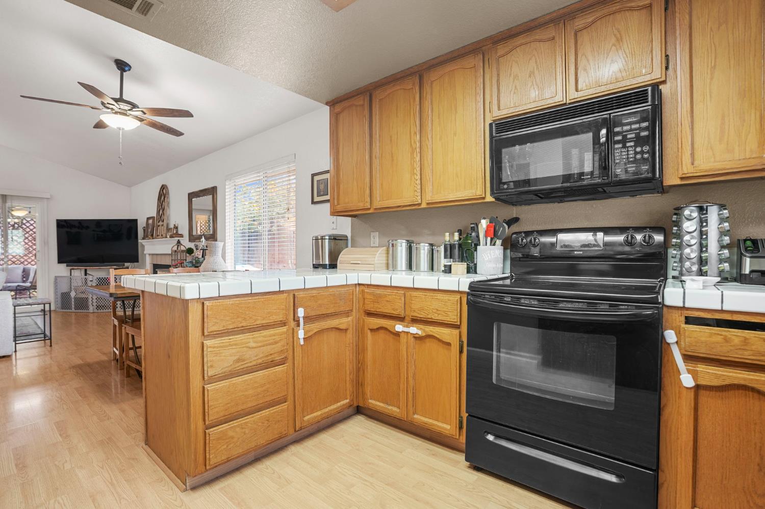 1017 Jayhawk Way Modesto, CA 95358 - Photo 11 of 32 a kitchen with stainless steel appliances granite countertop a stove top oven a sink dishwasher and white cabinets with wooden floor