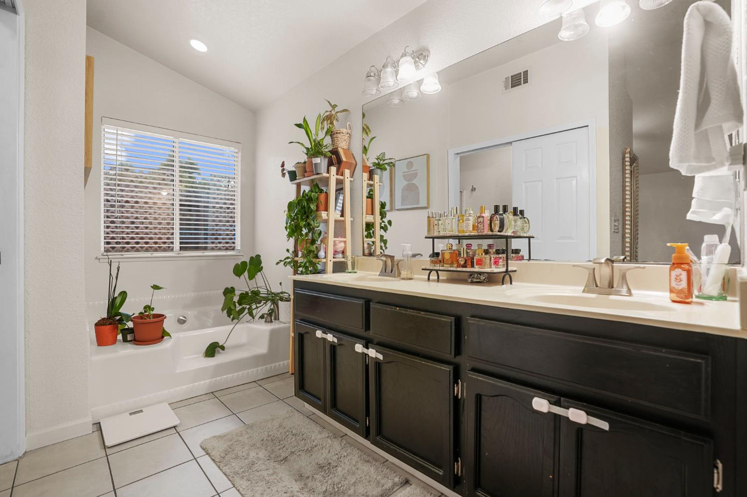 1017 Jayhawk Way Modesto, CA 95358 - Photo 14 of 32 a spacious bathroom with a sink double vanity and mirror