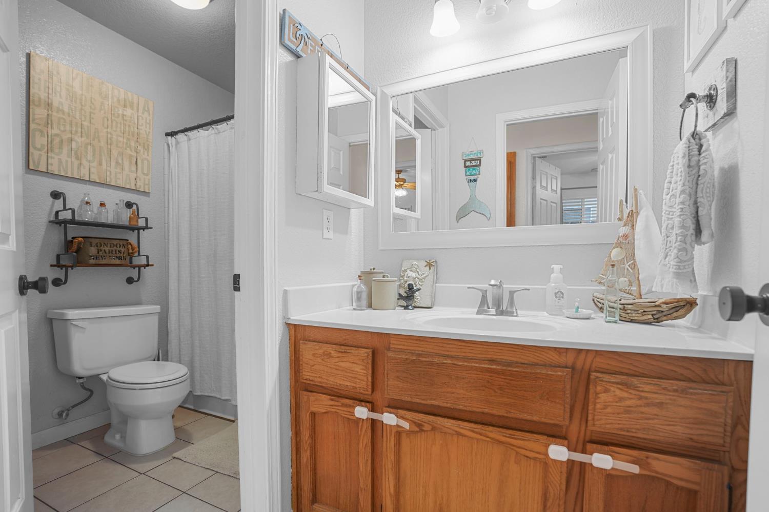 1017 Jayhawk Way Modesto, CA 95358 - Photo 18 of 32 a bathroom with a granite countertop sink toilet and mirror
