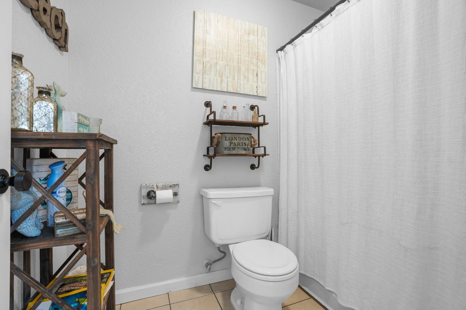 1017 Jayhawk Way Modesto, CA 95358 - Photo 19 of 32 a bathroom with a toilet and a shower curtain