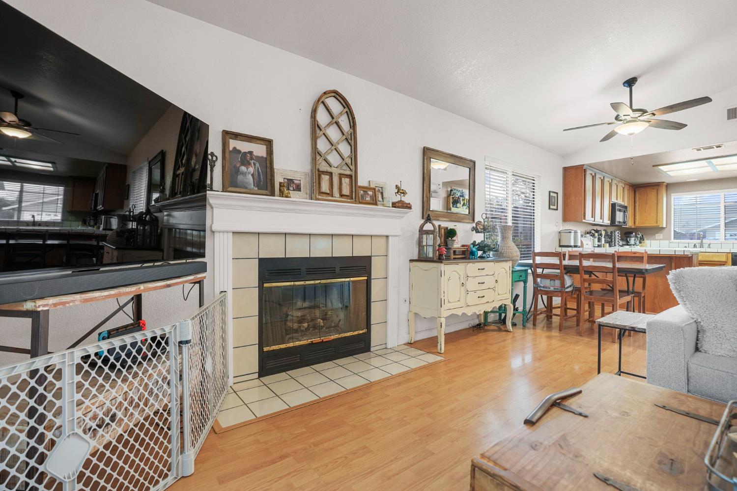 1017 Jayhawk Way Modesto, CA 95358 - Photo 7 of 32 a living room with furniture a fireplace and a kitchen view