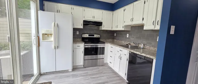 a kitchen with stainless steel appliances a refrigerator sink and cabinets
