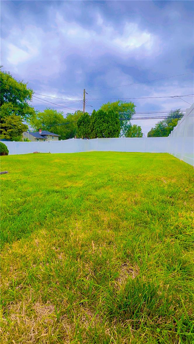 1844 29th Street Southwest Allentown, PA 18103 - Photo 32 of 37 A spacious green lawn is fully enclosed by secure vinyl privacy fencing under open skies.