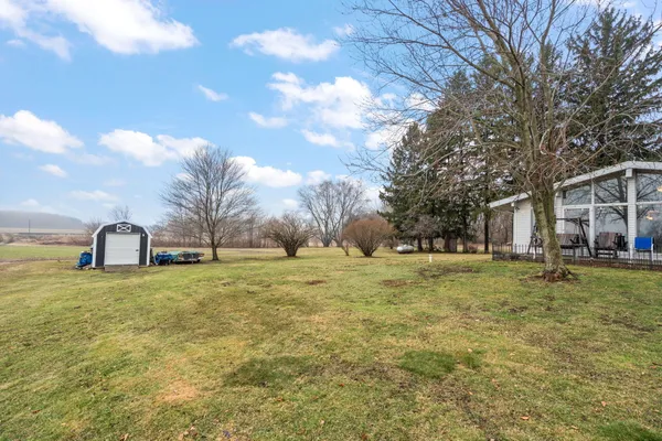 a white house in middle of a field of trees