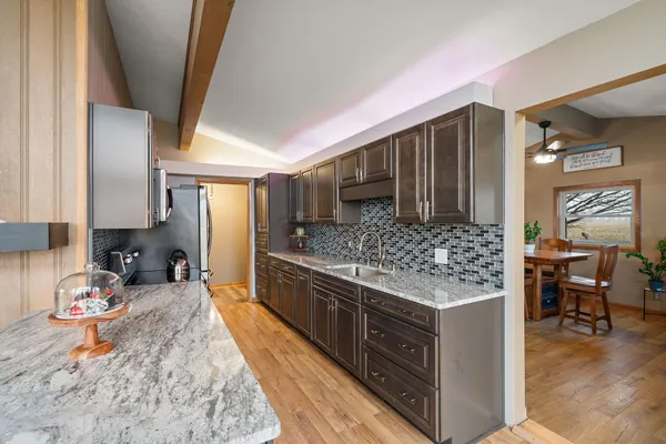 a kitchen with stainless steel appliances kitchen island granite countertop a stove refrigerator and cabinets