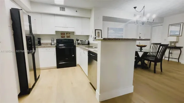 a view of a dining room with furniture and a chandelier