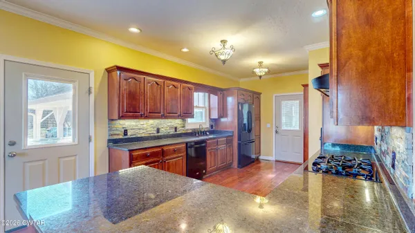 a kitchen with stainless steel appliances granite countertop a stove refrigerator and cabinets