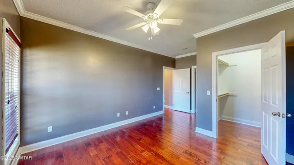 a view of a room with wooden floor and a ceiling fan