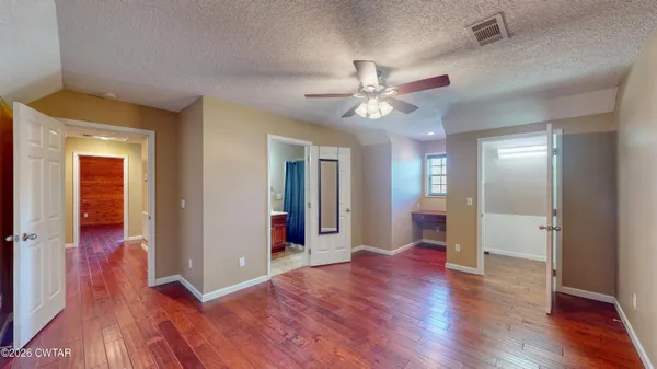a view of a hallway with wooden floor and chandelier