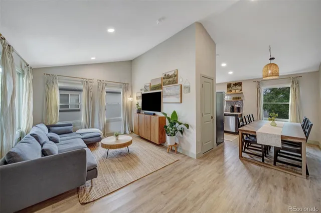 a living room with furniture and a wooden floor