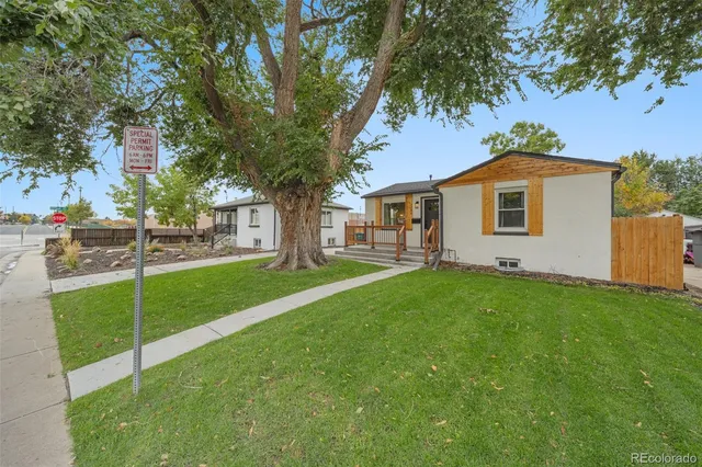 a view of a white house with a big yard and large trees