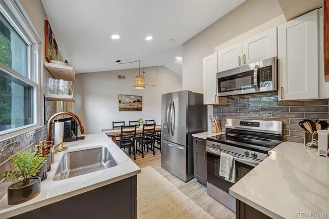 a kitchen with stainless steel appliances a stove microwave and sink