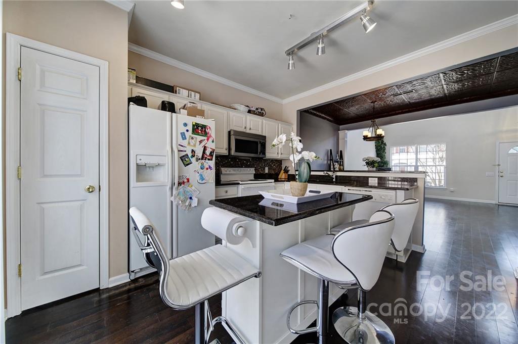 11428 Grove Point Road Charlotte, NC 28277 - Photo 11 of 36 a kitchen with granite countertop a table chairs microwave and cabinets