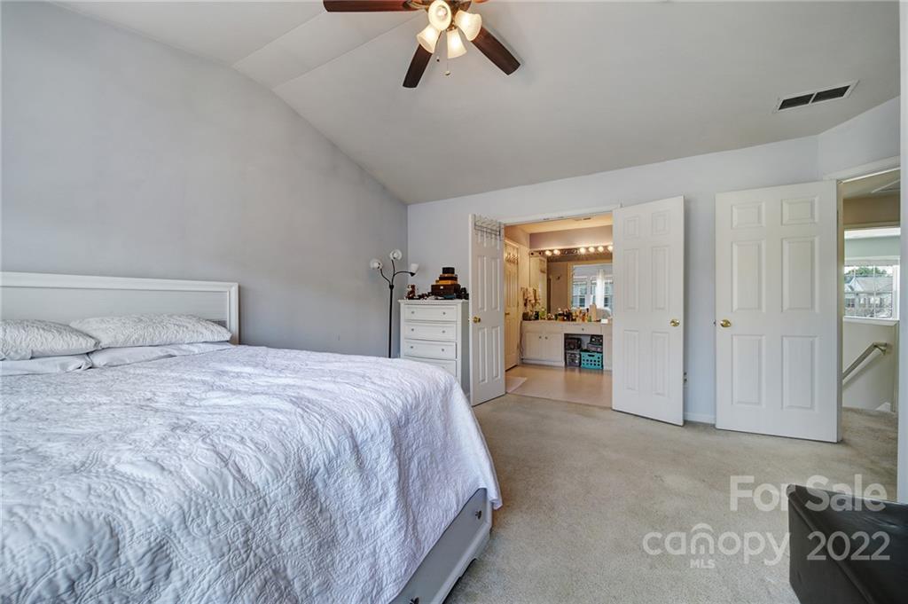 11428 Grove Point Road Charlotte, NC 28277 - Photo 19 of 36 a spacious bedroom with a bed and a chandelier