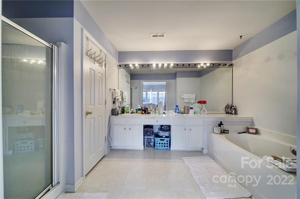 11428 Grove Point Road Charlotte, NC 28277 - Photo 20 of 36 a large bathroom with a tub a sink and mirrors