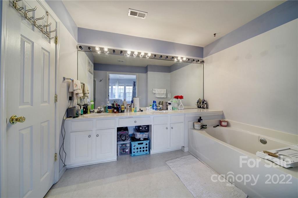 11428 Grove Point Road Charlotte, NC 28277 - Photo 21 of 36 a spacious bathroom with a double vanity sink a mirror a bathtub and a shower