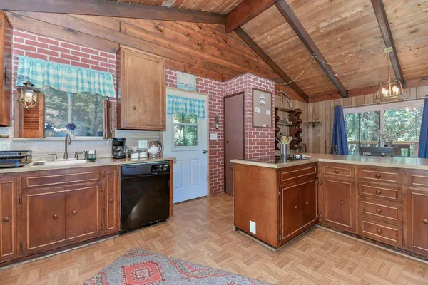 a kitchen with stainless steel appliances granite countertop a sink a stove and a wooden cabinets