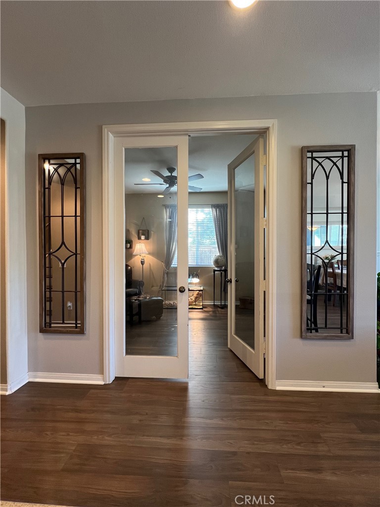 1433 Fall Brook Road Beaumont, CA 92223 - Photo 15 of 33 a view of a hallway with wooden floor and a living room
