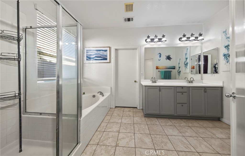 1433 Fall Brook Road Beaumont, CA 92223 - Photo 18 of 33 a spacious bathroom with a double vanity sink mirror and bathtub