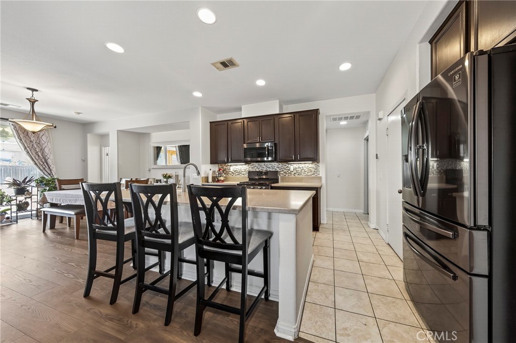 1433 Fall Brook Road Beaumont, CA 92223 - Photo 6 of 33 a kitchen with stainless steel appliances kitchen island granite countertop a refrigerator a stove a sink and a refrigerator