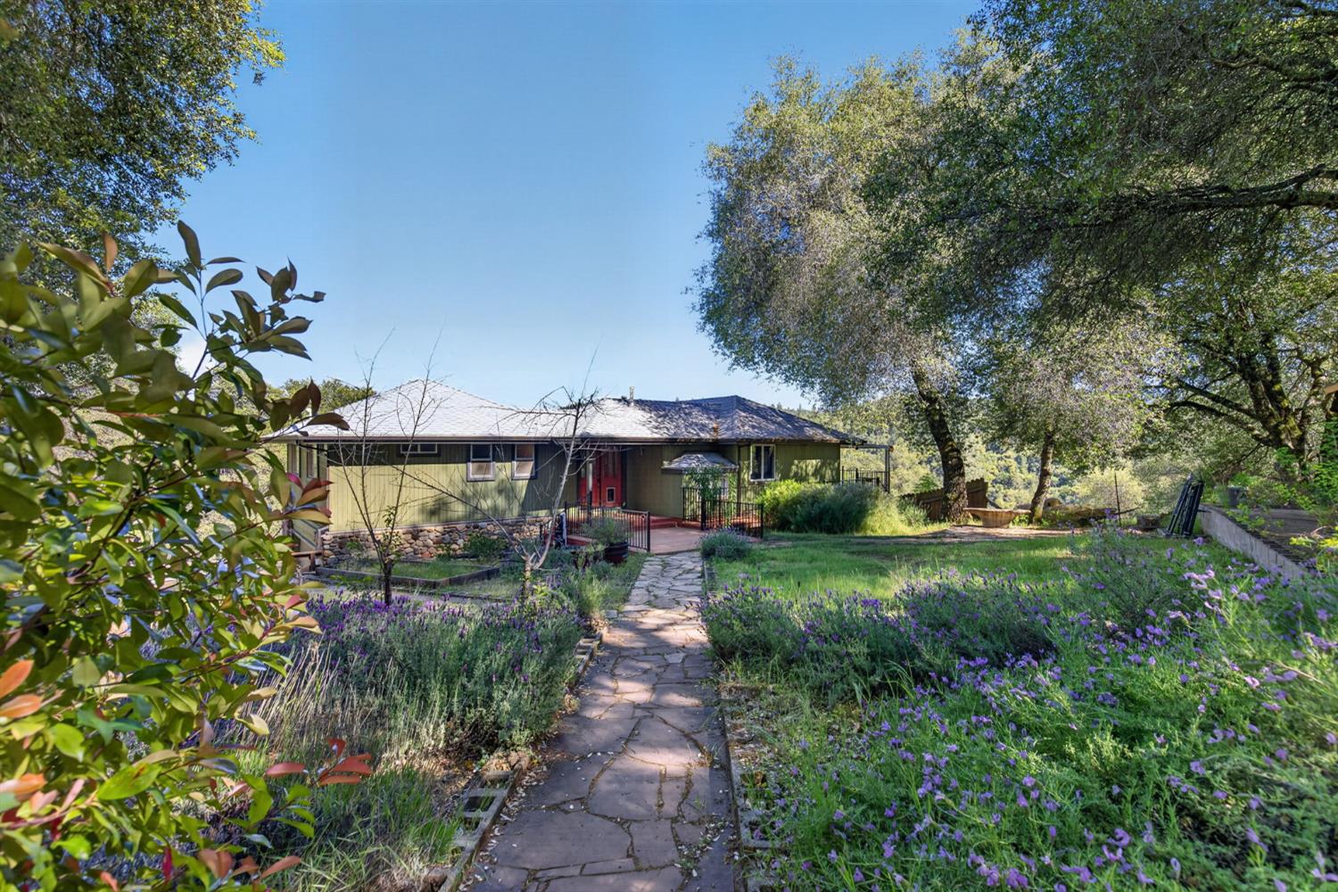 4450 Cosumnes View Trail Placerville, CA 95667 - Photo 42 of 69 a view of a garden with a table and chairs under an umbrella