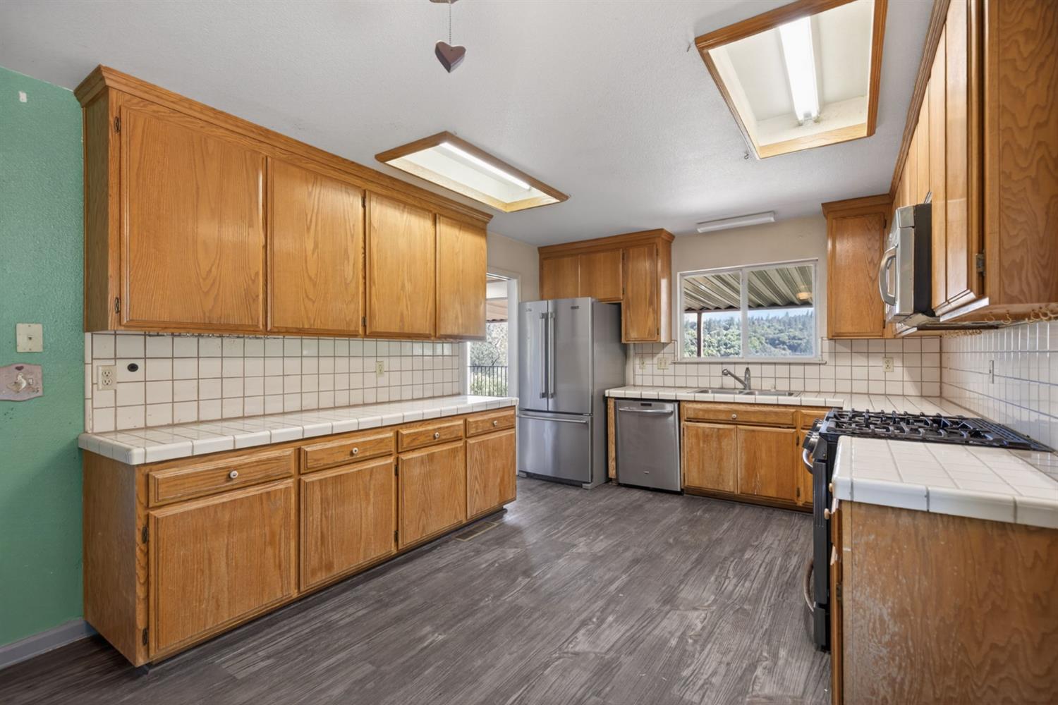 4450 Cosumnes View Trail Placerville, CA 95667 - Photo 9 of 69 a kitchen with stainless steel appliances granite countertop wooden cabinets a sink and dishwasher with wooden floor