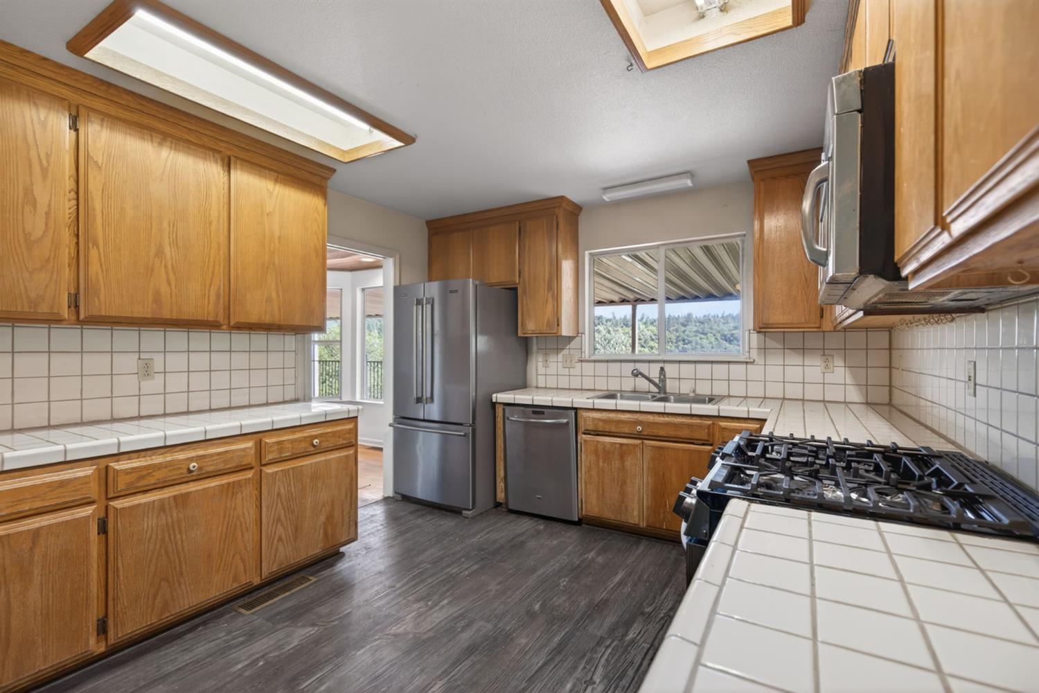4450 Cosumnes View Trail Placerville, CA 95667 - Photo 10 of 69 a kitchen with stainless steel appliances a stove a sink a refrigerator wooden floor and cabinets