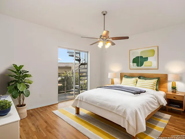 an empty room with wooden floor fan and window