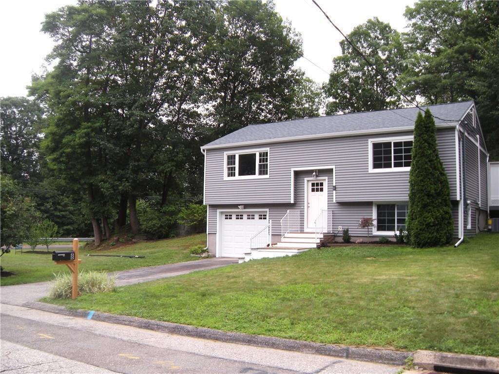 a front view of a house with a yard and trees