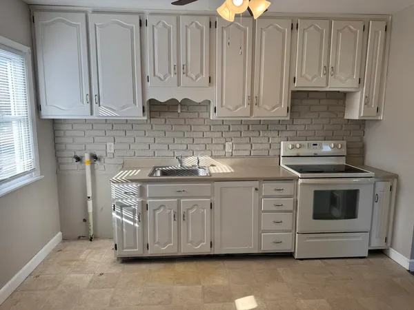 a kitchen with stainless steel appliances granite countertop a sink a stove and cabinets