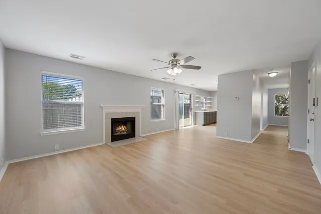 a view of an empty room with a fireplace and window