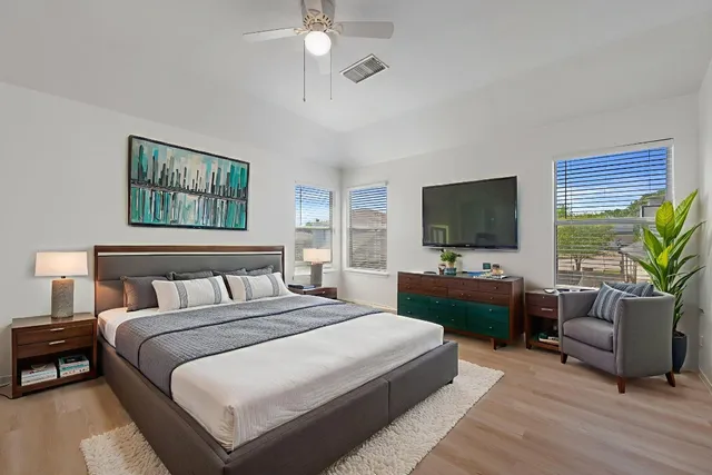 a bedroom with a large bed and a flat screen tv