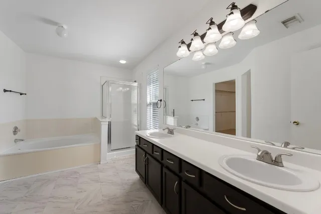 a spacious bathroom with a double vanity sink mirror and a bathtub
