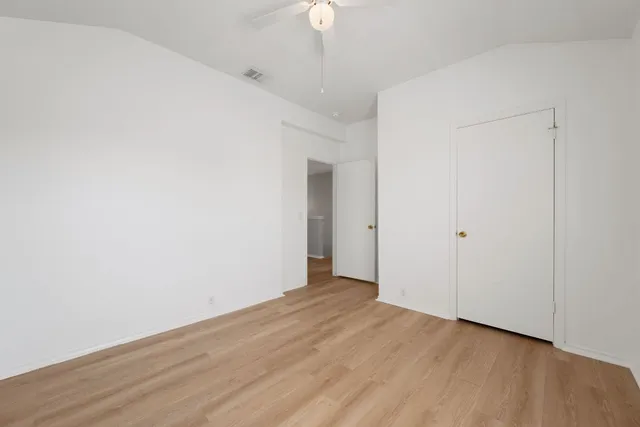 a view of an empty room with wooden floor