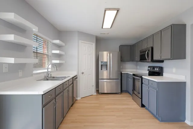 a kitchen with stainless steel appliances granite countertop a sink stove and refrigerator