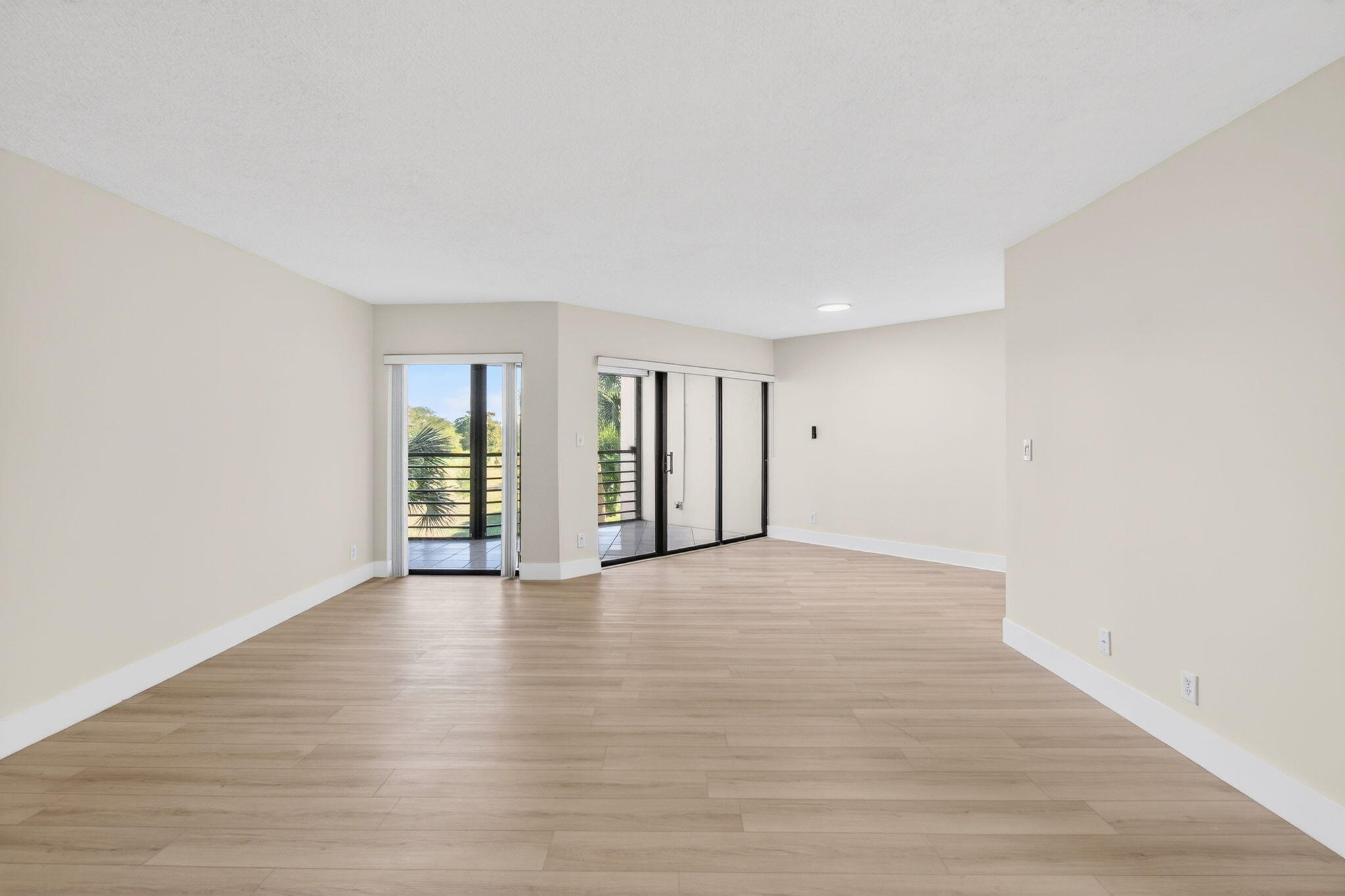 5900 Camino Del Sol, Unit 304 Boca Raton, FL 33433 - Photo 16 of 82 a view of an empty room with wooden floor and windows