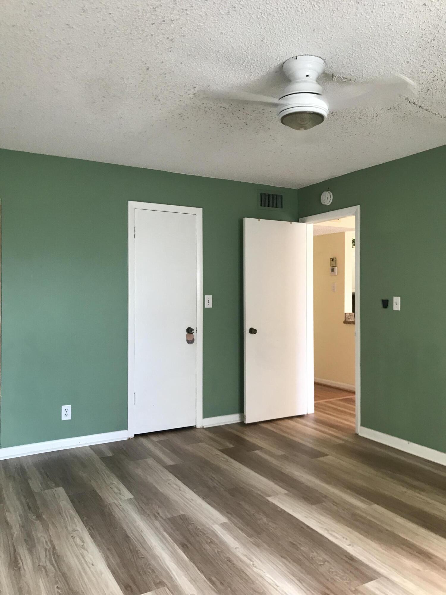 9355 Southwest 8th Street, Unit 121 Boca Raton, FL 33428 - Photo 13 of 35 an empty room with wooden floor and windows