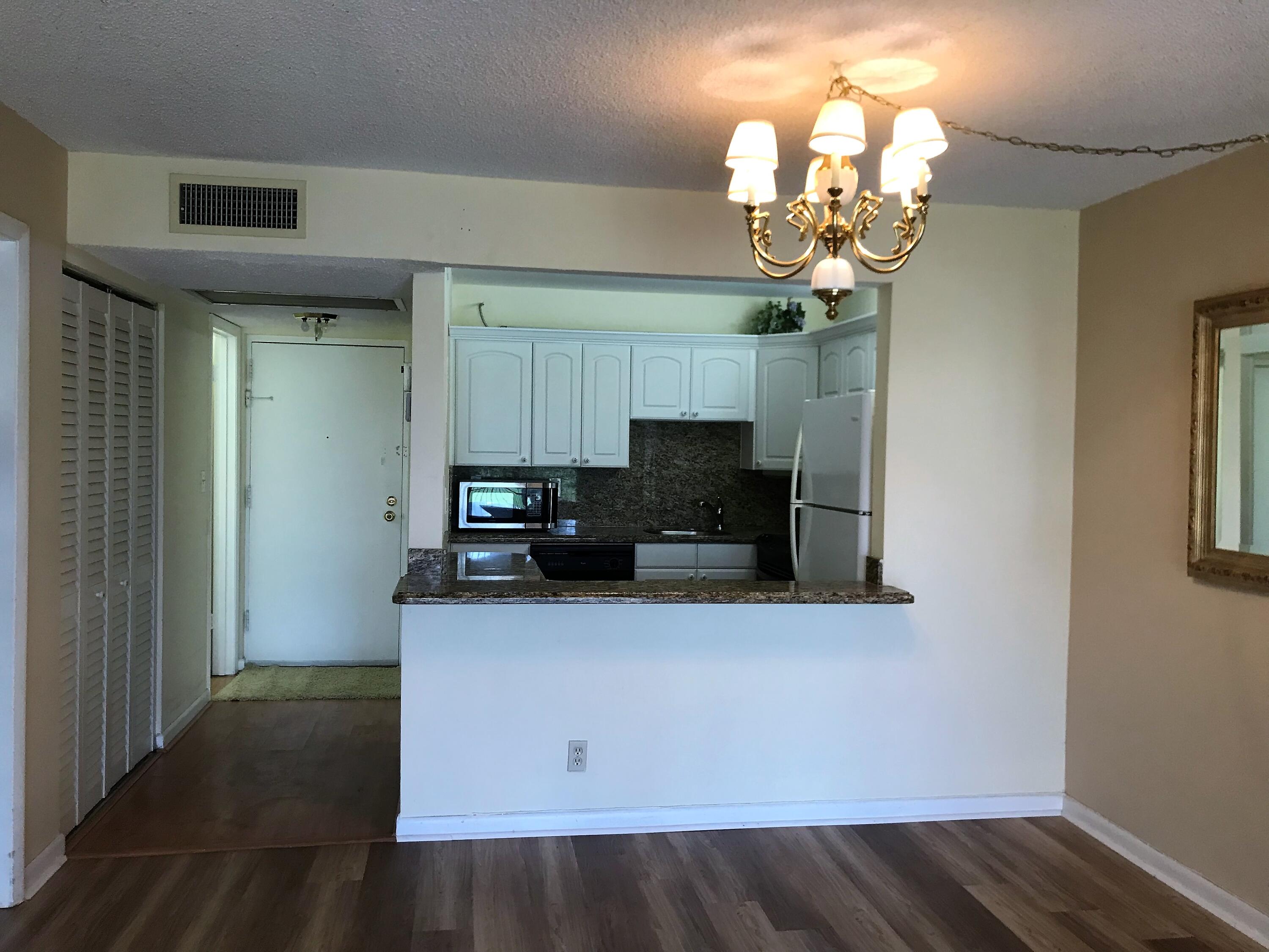 9355 Southwest 8th Street, Unit 121 Boca Raton, FL 33428 - Photo 4 of 35 a kitchen with a refrigerator and a stove top oven