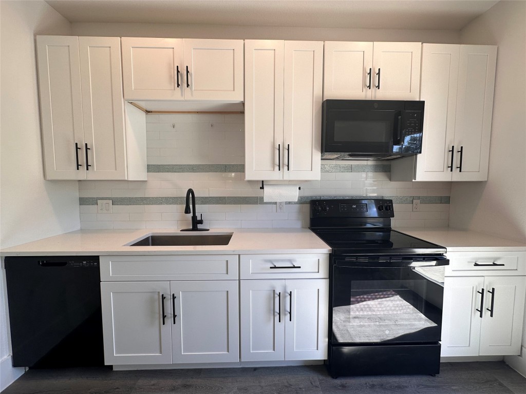 720 Neches Street Lockhart, TX 78644 - Photo 4 of 12 Kitchen featuring black appliances, white cabinetry, backsplash, and light quartz countertops