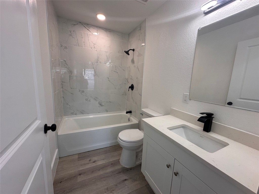 720 Neches Street Lockhart, TX 78644 - Photo 8 of 12 Bathroom featuring vanity, light wood finished floors, and a shower / bath combination