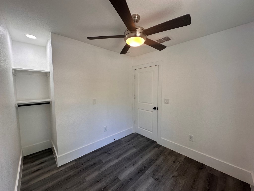 720 Neches Street Lockhart, TX 78644 - Photo 9 of 12 Second bedroom with dark wood finished floors and a ceiling fan