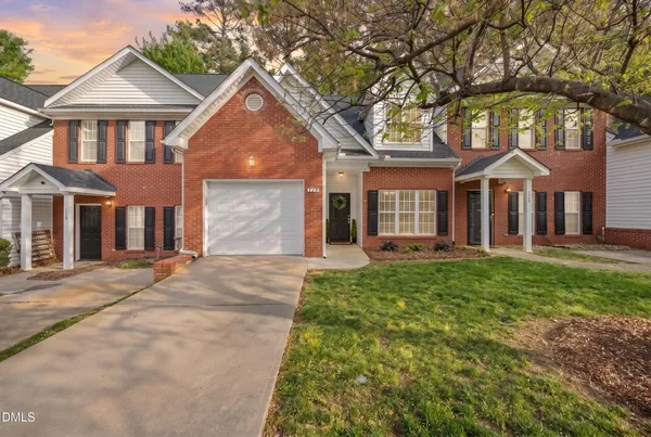 front view of a brick house with a yard