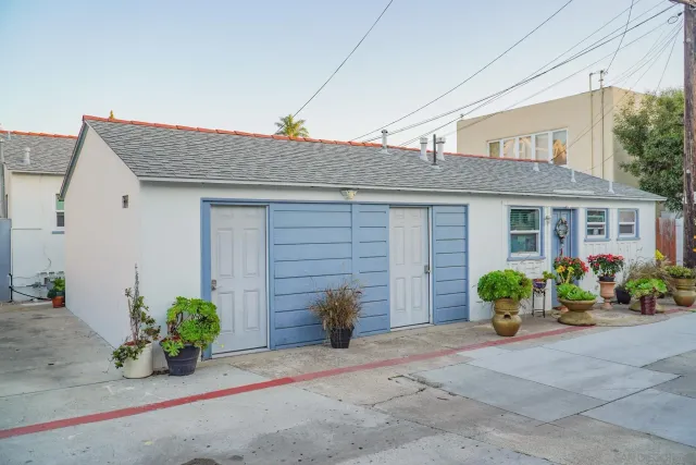 a front view of a house with potted plants